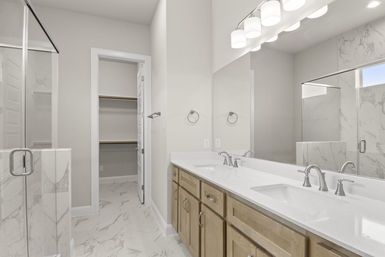 View of primary bathroom with walk-on shower and dual-vanity