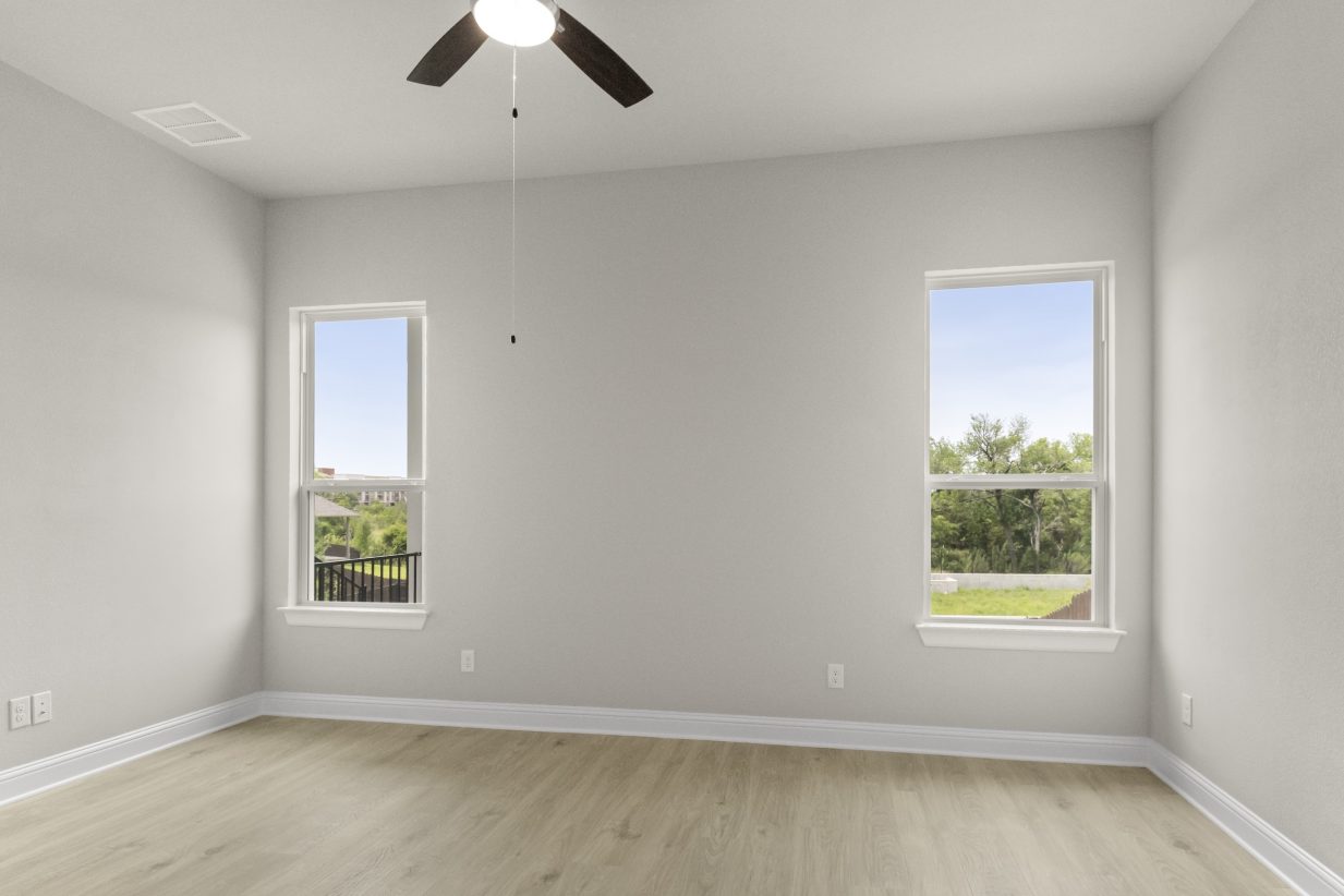 View of primary bedroom with two windows